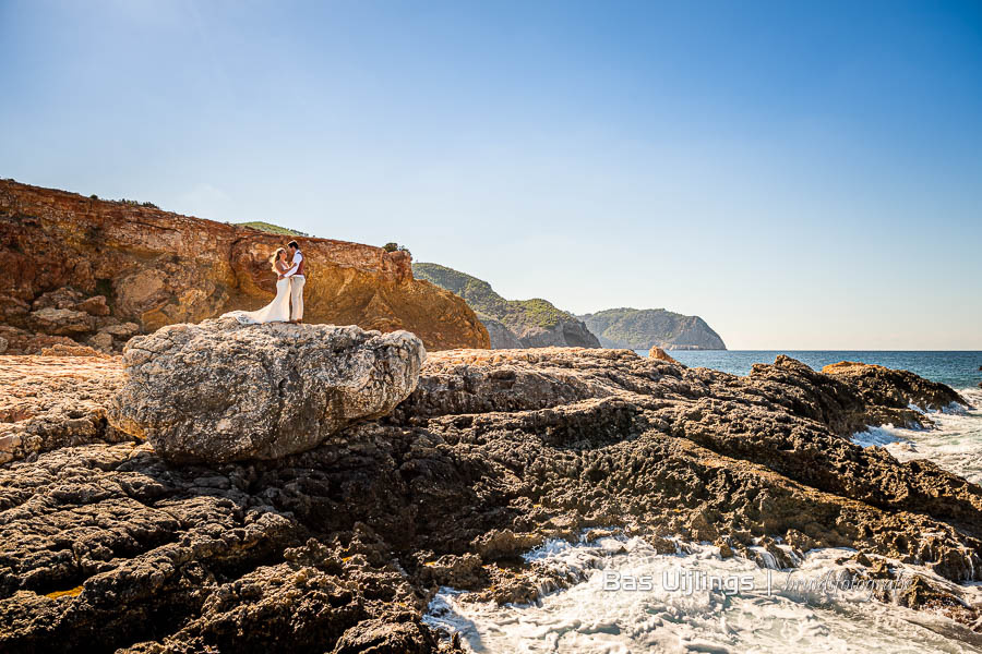 Trouwen op ibiza - bruidspaar rots aan zee